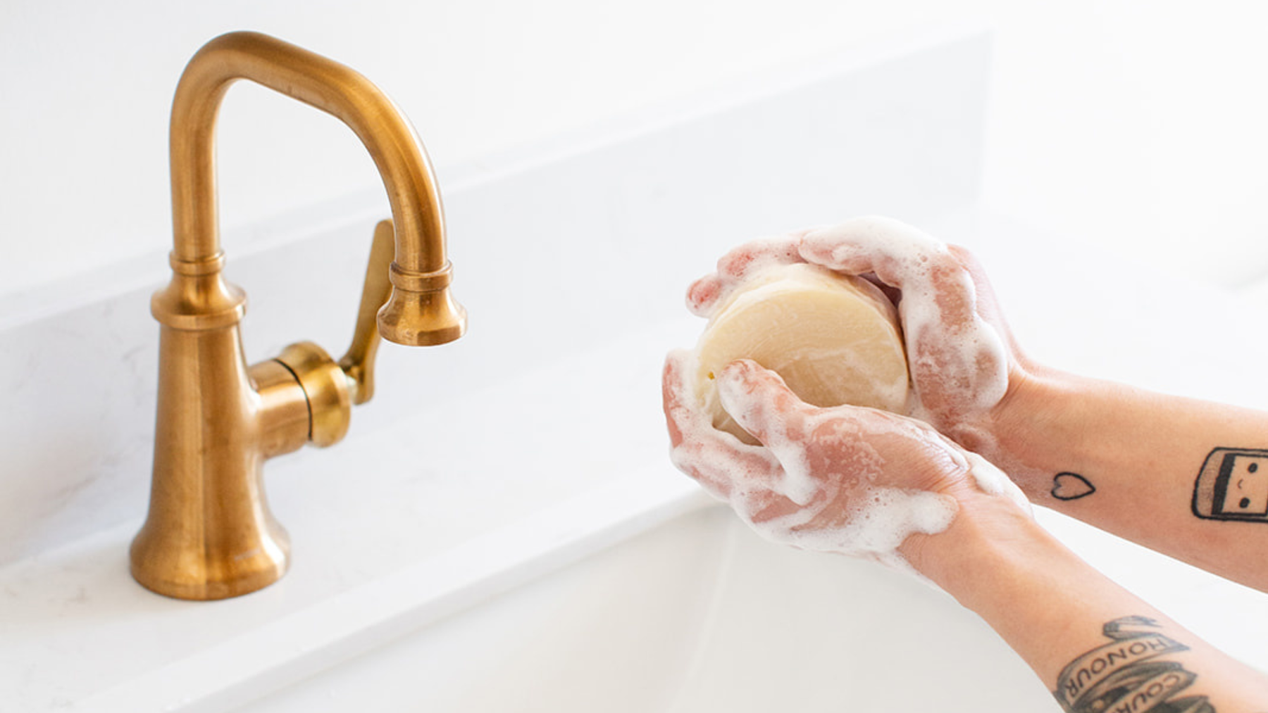 Handcrafted natural bar soap beside a bottle of body wash comparing the benefits of each for healthy skin.