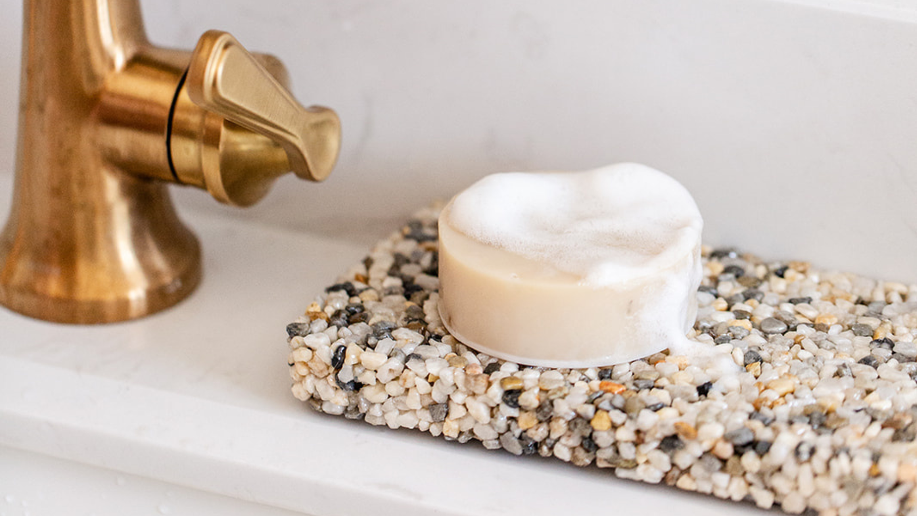 natural bar soap drying on a stone soap plate