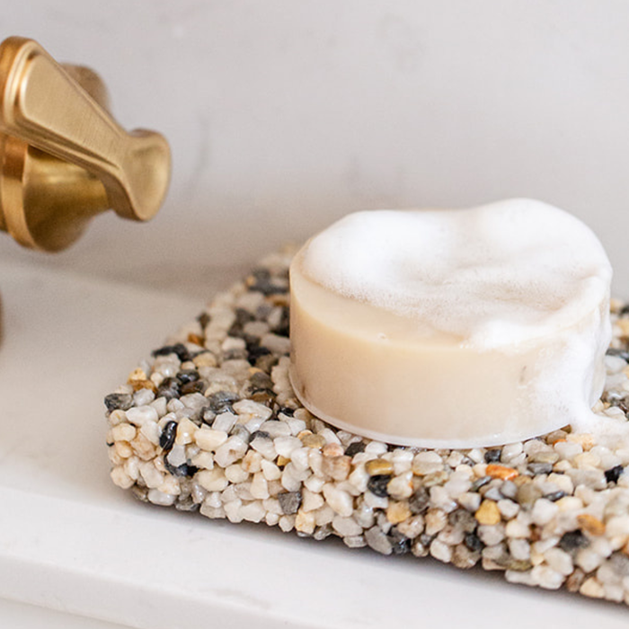 natural bar soap drying on a stone soap plate