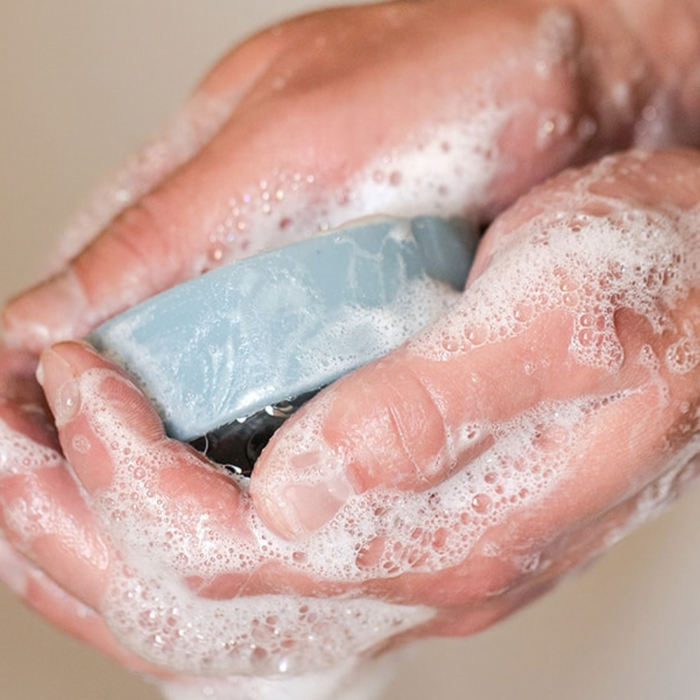 Hands building a creamy lather with a Wild Prairie natural bar soap