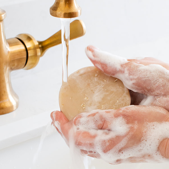 Comparison of plastic body wash bottles versus natural bar soap wrapped in recyclable paper