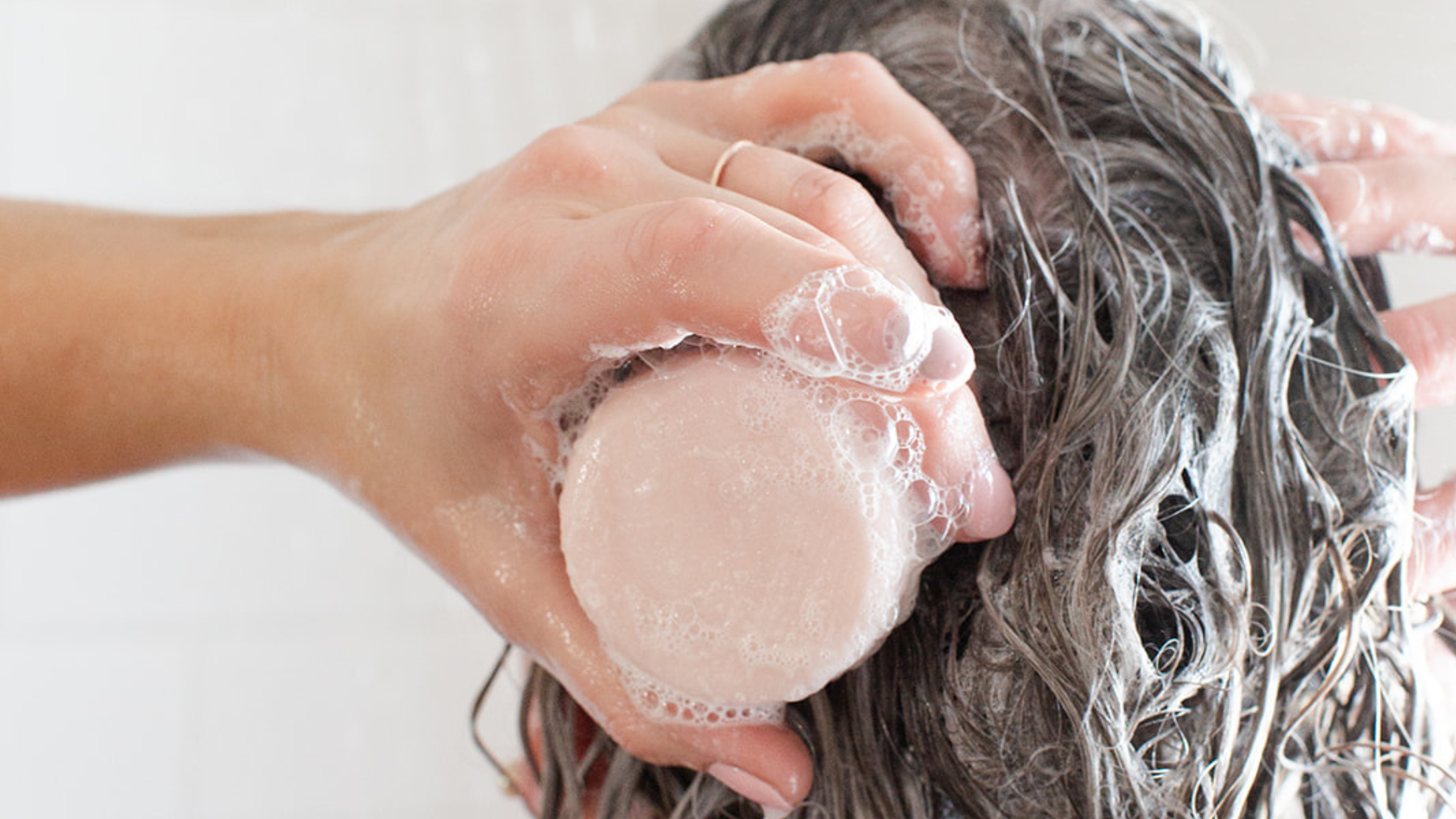 Wild Prairie natural shampoo and conditioner bars stored on a draining stone soap dish to extend lifespan