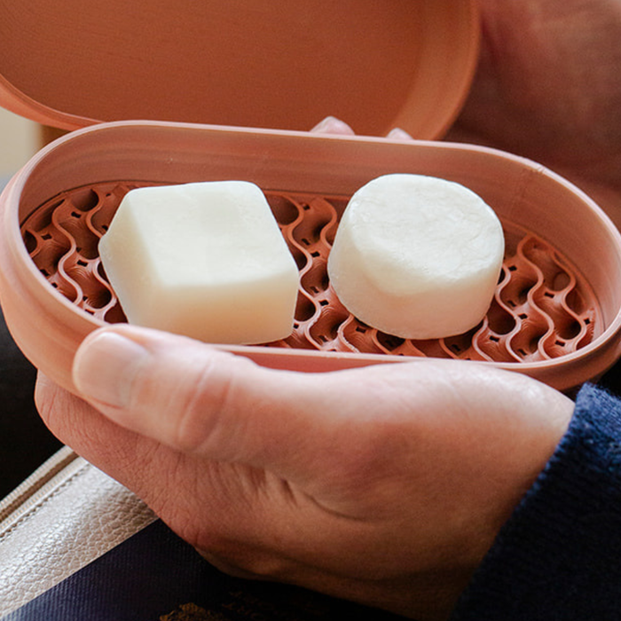 solid shampoo bars packed for travel with toiletry bag and airplane essentials